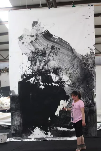 工作室悬挂的竖幅大型水墨作品与前方人物